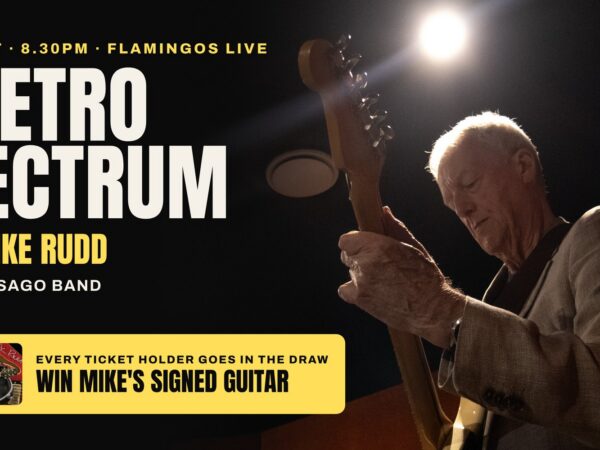 Mike Rudd playing guitar under a spotlight. A Retro Spectrum with Mike Rudd, Sat 24 Oct, Flamingos Live. Every ticket holder goes in the draw to win Mike's signed guitar.